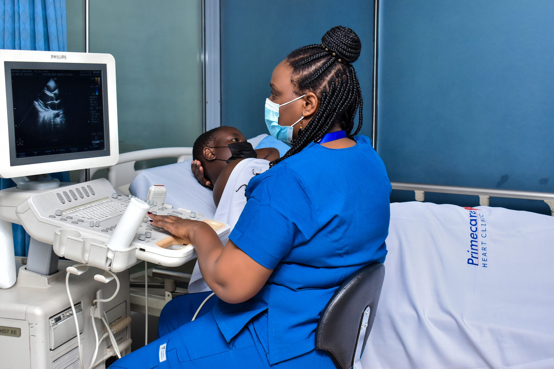 A sonographer performing an echocardiogram with the heart shown on the ultrasound screen